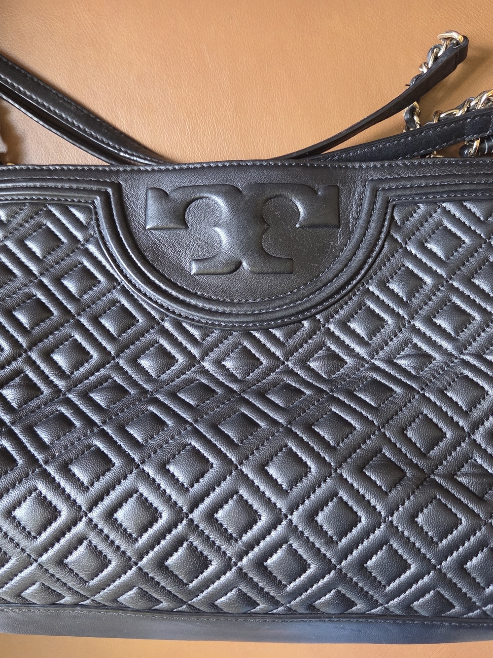 Tory Burch Fleming quilted leather open shoulder bag in black.